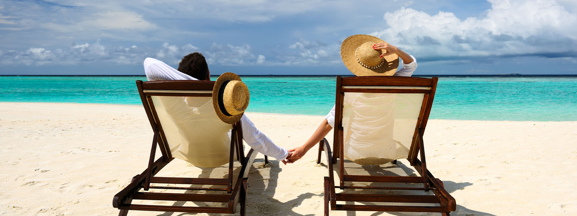 A couple sitting in chairs on a beach