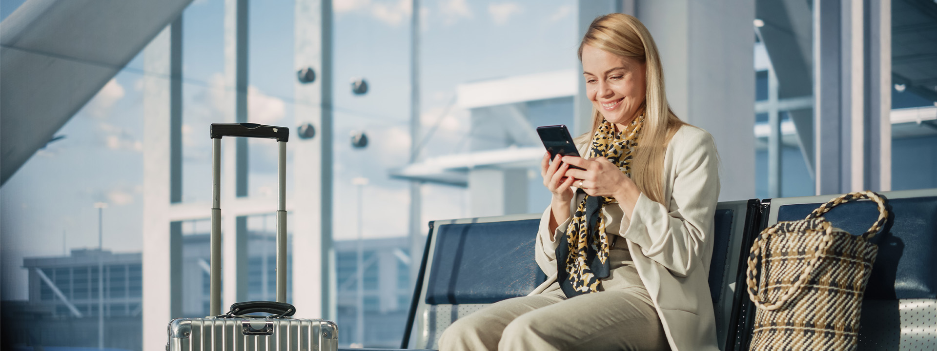 A woman holds a phone with a Visa payment app in a lively sports bar, surrounded by cheering fans watching a soccer match on TV.